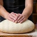 Pétrissage manuel de la pâte à pain sur une table de boulangerie